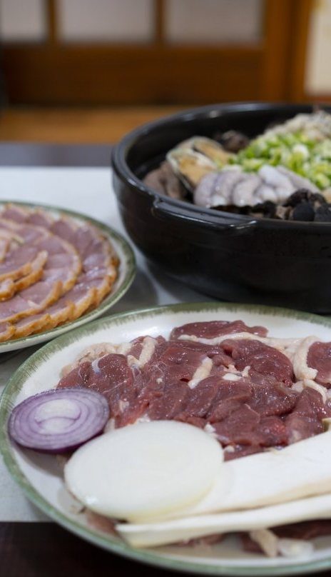 생오리 접시 뒤로 훈제오리 접시와 백숙 냄비가 놓인 상